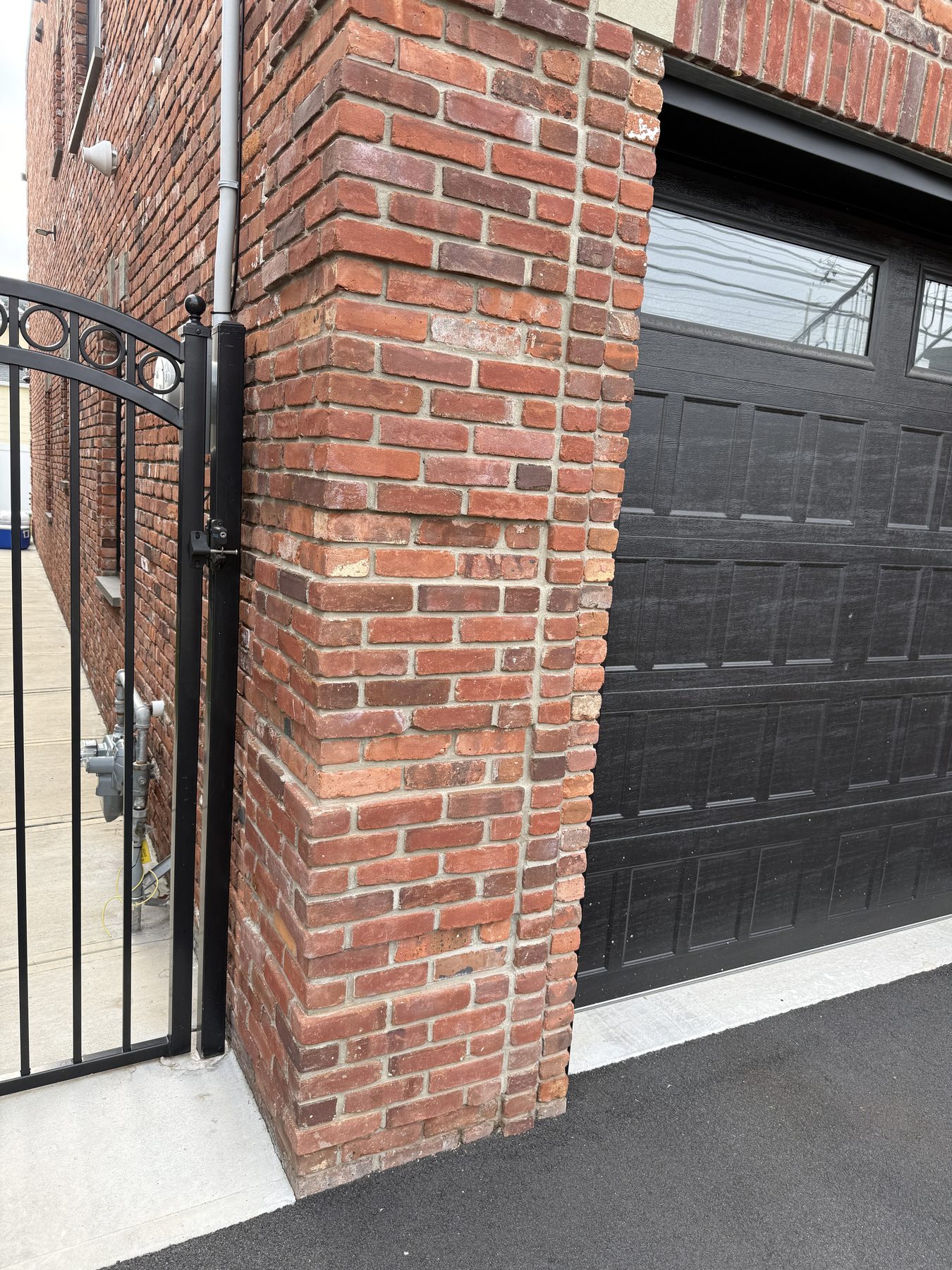 Reference photograph of varied red brick beside a black overhead door