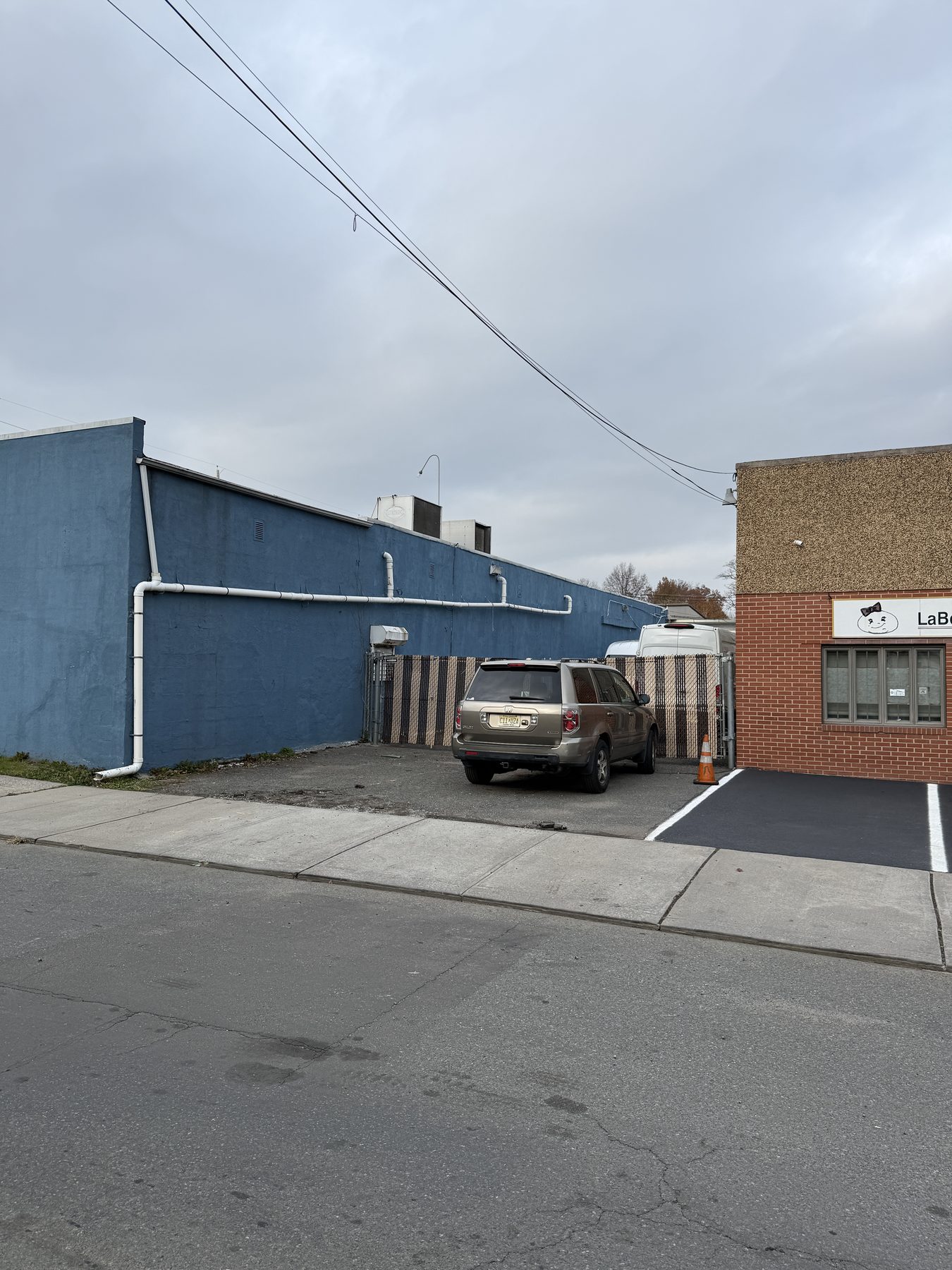 Existing vacant infill lot between low industrial buildings in Kearny